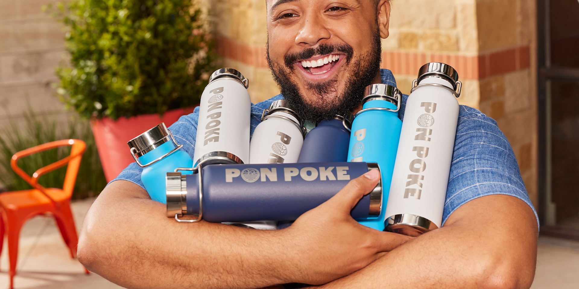 A smiling person holding custom water bottles.