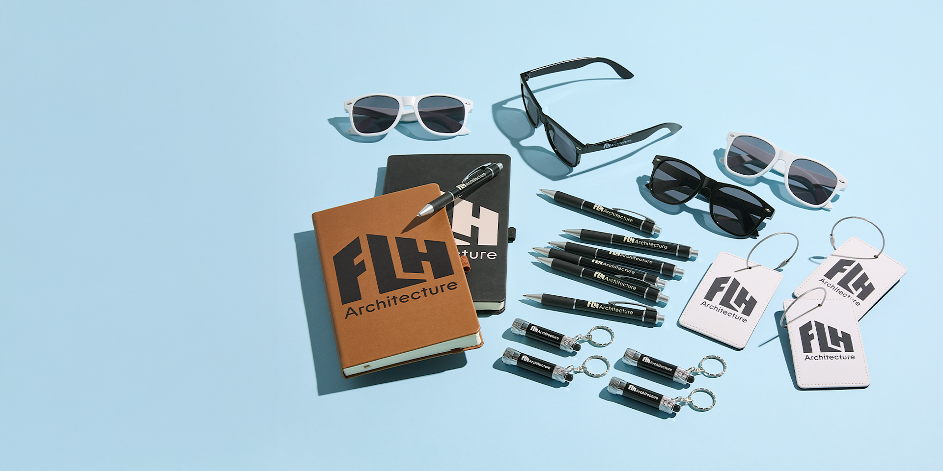 An assortment of new arrival promotional products, including custom sunglasses, pens and keychains.