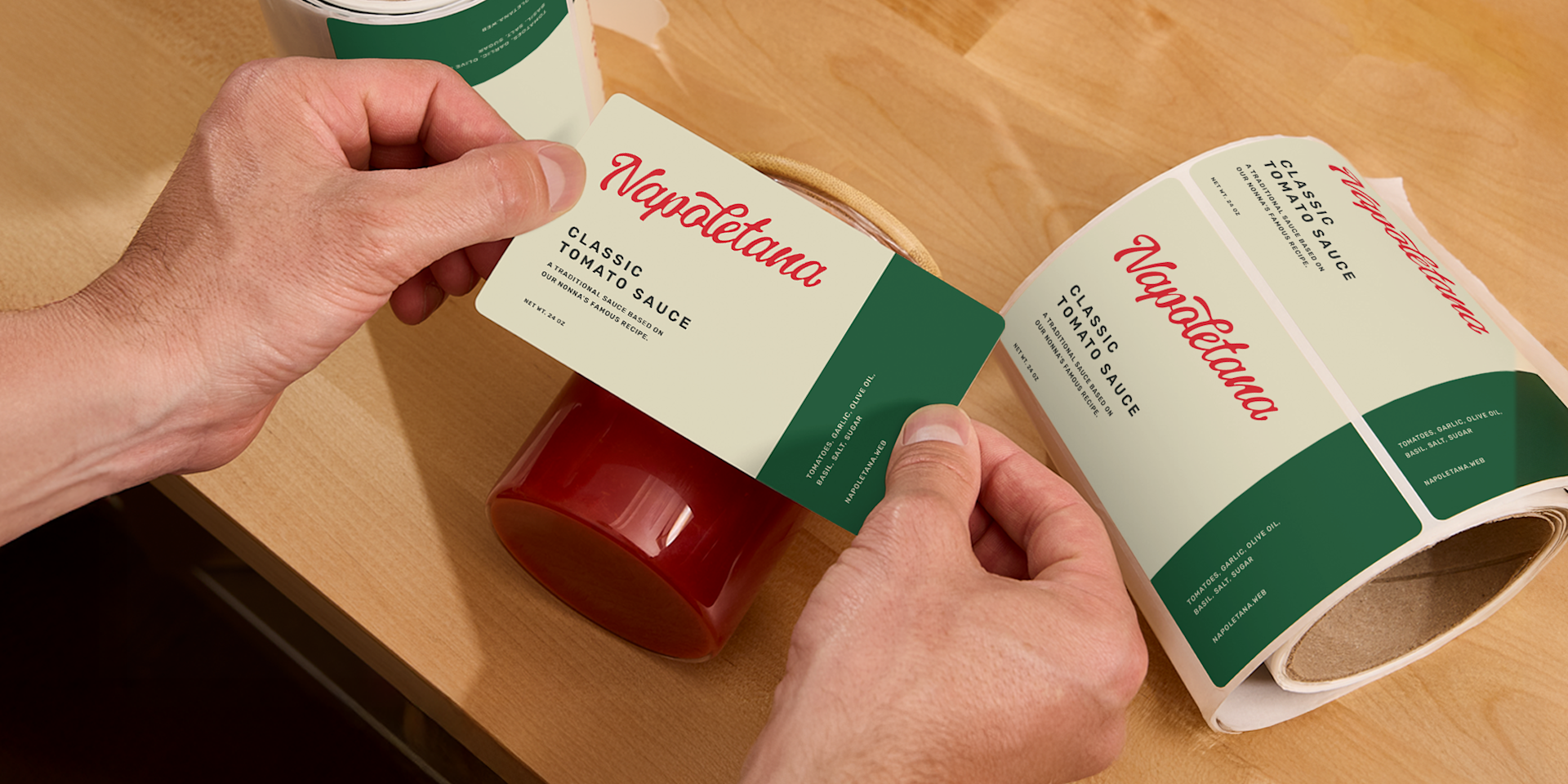 A person taking a label from a roll and applying it to a jar of traditional tomato sauce.