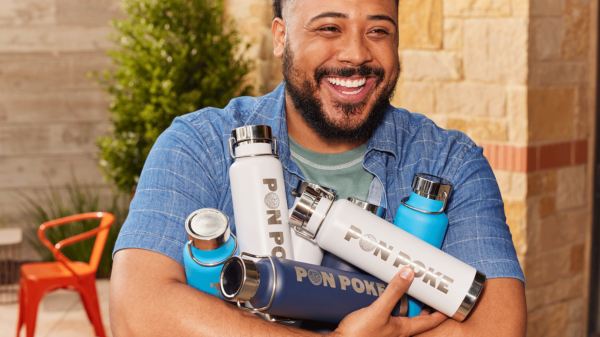 A smiling person holding custom water bottles.