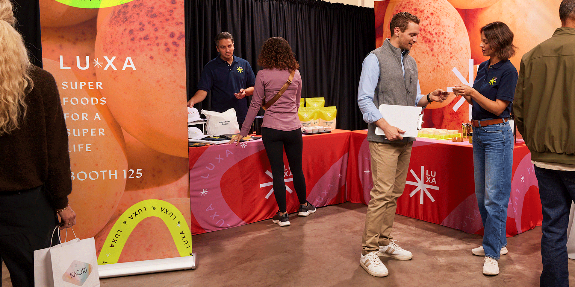 An indoor trade show display, featuring a tablecloth, retractable banner and promotional merchandise. 