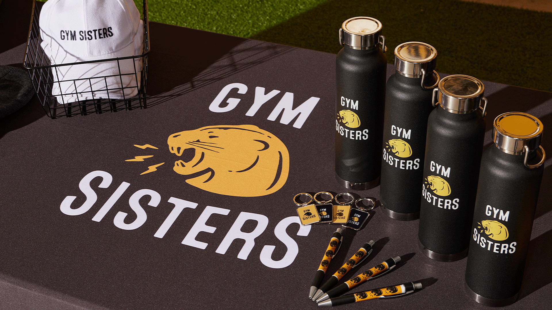 An assortment of custom bottles, pens, hats and keychains promoting a gym business.