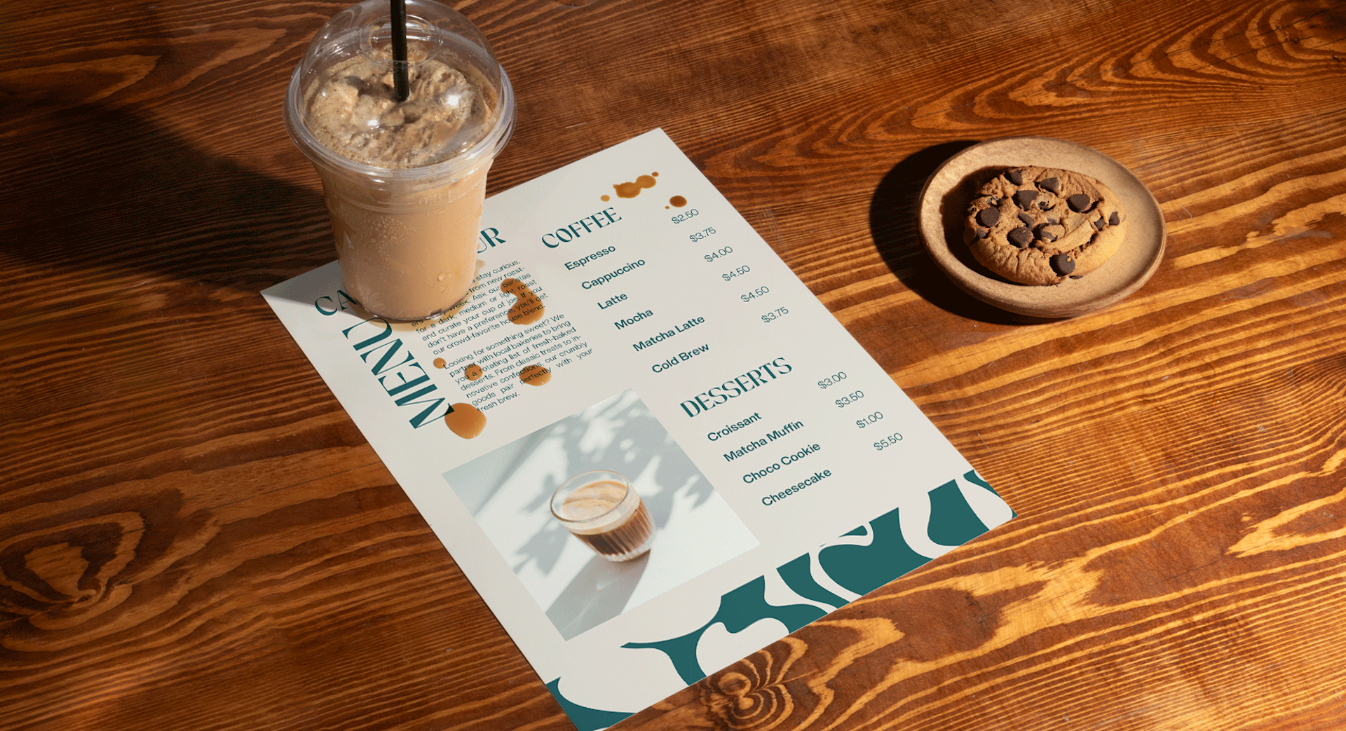 A flat synthetic menu on a cafe table with a frozen drink and cookie, undamaged by a small spill.