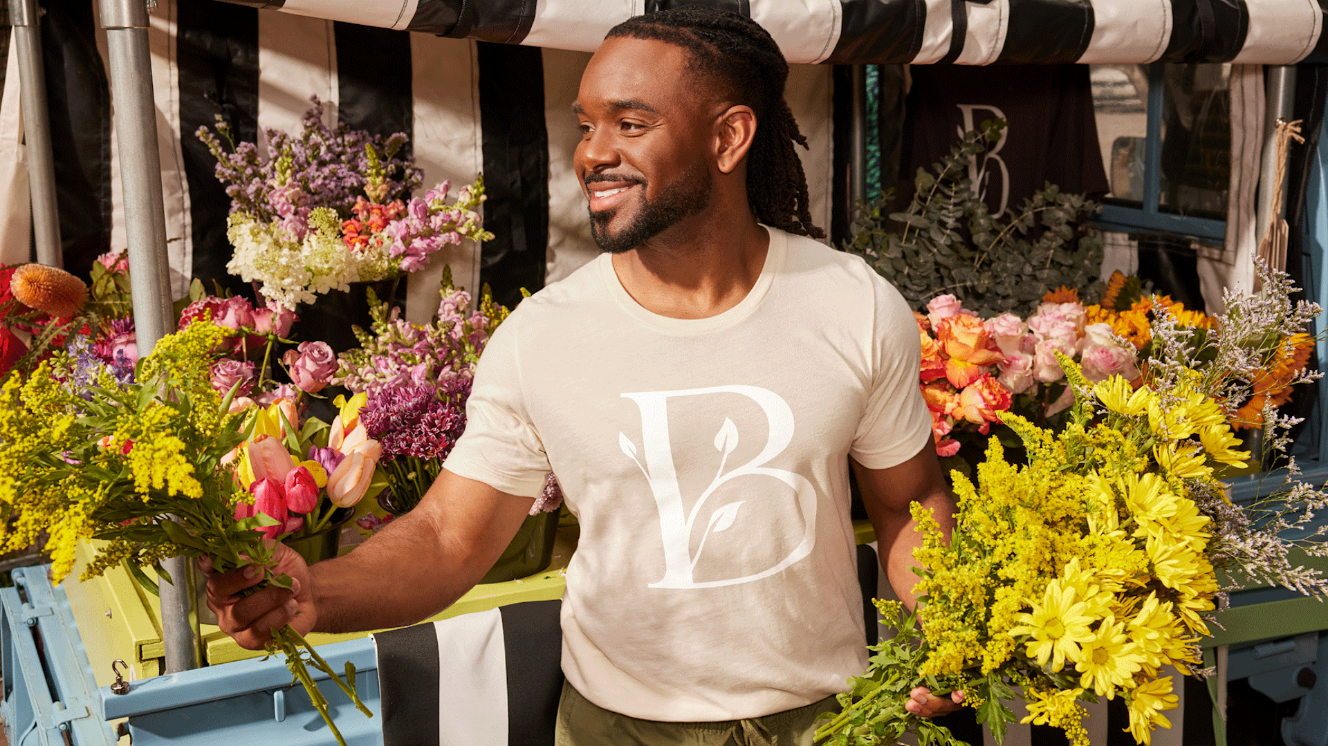 A flower truck owner wearing a custom T-shirt promoting his business.