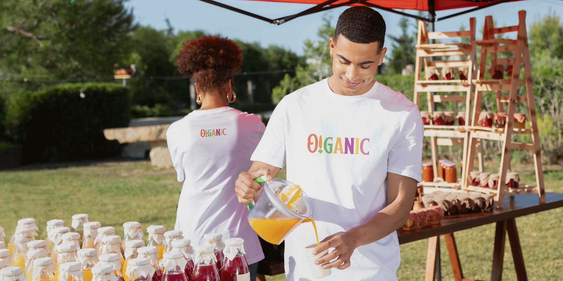 Man pouring orange juice while wearing a white custom T-shirt.