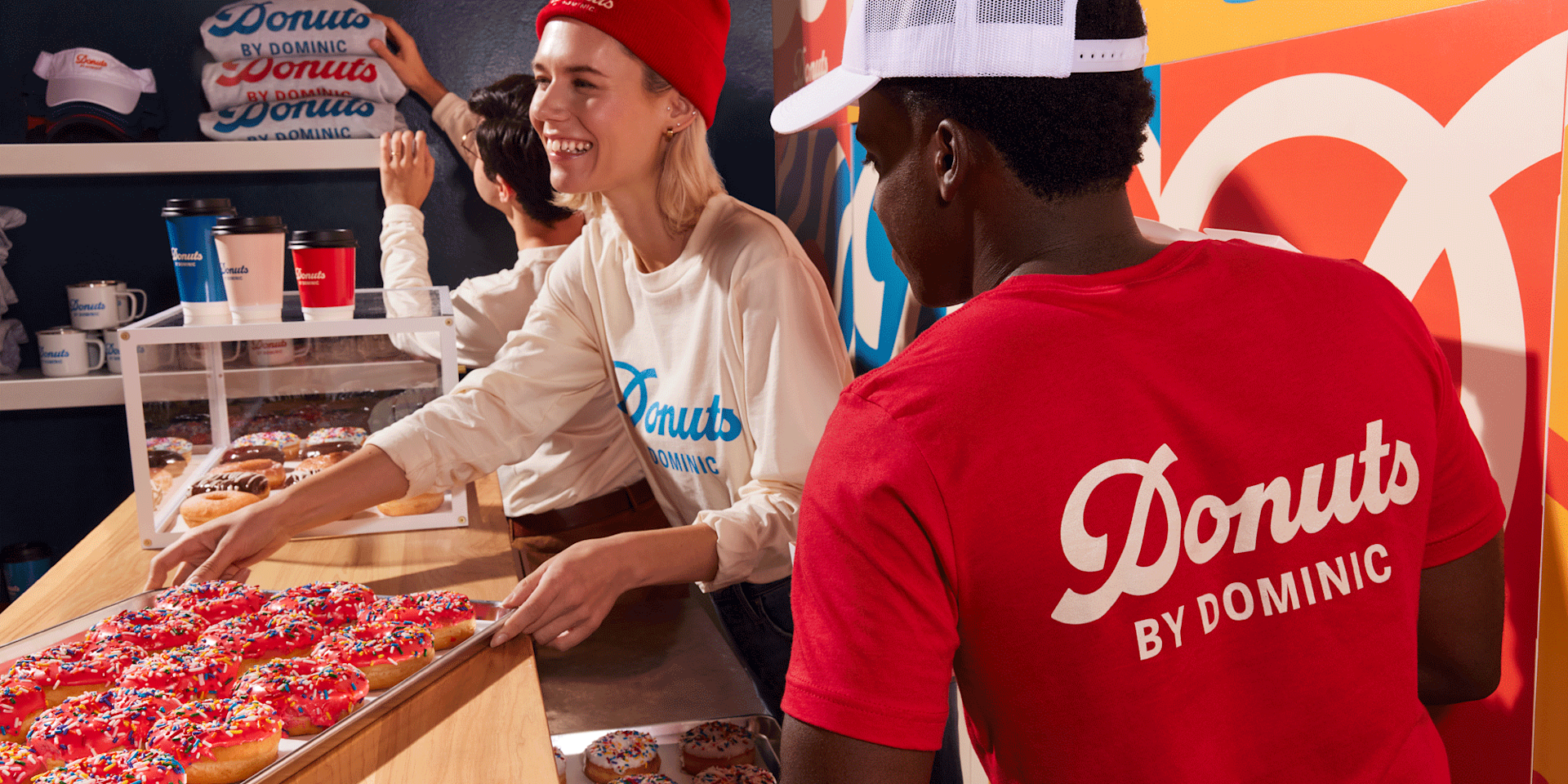 Man at a donut shop counter wearing a T-shirt with a custom backside.