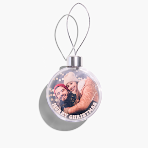 A personalised Christmas bauble featuring a photo of a young couple embracing. 