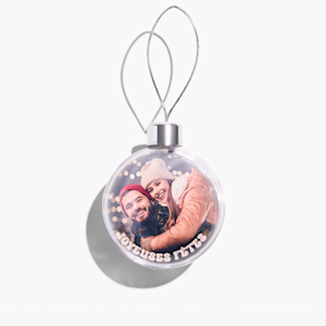 Boule de Noël personnalisée avec la photo d’un jeune couple s’enlaçant. 