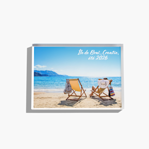Bloc photo plexi sur lequel figure une plage ensoleillée, accompagnée du texte : « Île de Brač, Croatie, été 2026\. » 