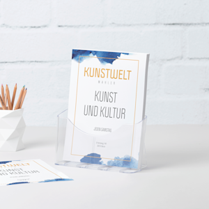 Ein DIN-A4-Flyerhalter aus Kunststoff mit Flyern einer Galerie auf einem Schreibtisch neben einem Stiftbecher.