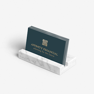 A marble business card holder with business cards advertising a finance business.