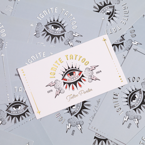 A raised foil business card promoting a tattoo parlor.