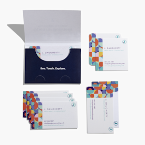 An overhead view of the business card sample kit, with stacks of business cards alongside an open card holder on a white background.