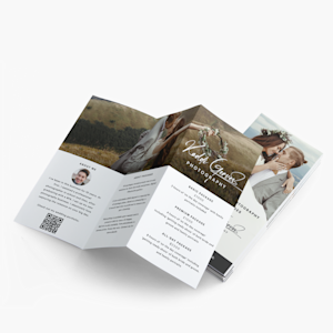 An open Z-fold brochure advertising a wedding photographer, with a stack of folded Z-fold brochures behind it.