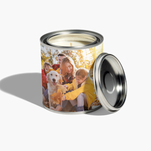 A personalised photo candle printed with a photo of a family and their golden retriever playing in autumn leaves.