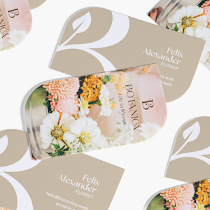 Leaf shaped business cards promoting a floral business, with a photo at the front and contact details on the back.