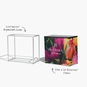 The assembled aluminium frame next to a fully-assembled trade show display counter, promoting a flower shop. An arrow points to the lightweight aluminium and the fade & UV-resistant fabric.