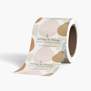 A roll of Self-Adhesive Packaging Tape on a gray background, featuring a a repeating design for a knitting business