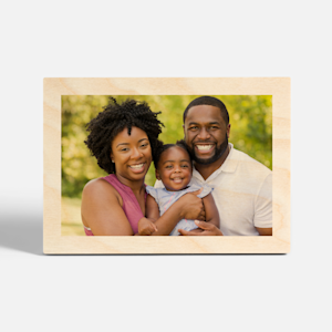 A tabletop wood print featuring a photo of a couple and their toddler. 
