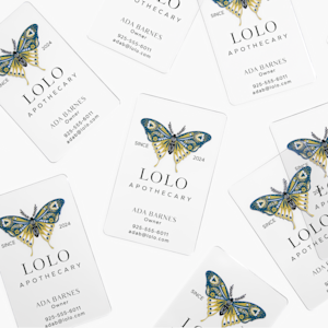 Clear plastic business cards for an organic health store owner, scattered on a surface.