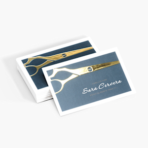 Un par de tarjetas de presentación, una con relieve metalizado dorado y la otra con metalizado plateado promocionando una empresa en la industria de la moda.