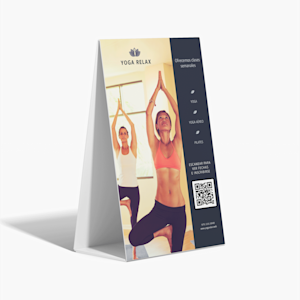 Un caballete publicitario corrugado sobre un fondo gris, promocionando un estudio de yoga. El diseño incluye un código QR para ayudarle a los clientes a inscribirse a las clases.