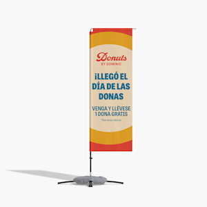 Una bandera rectangular colorida de donas gratis en una base para pavimento.