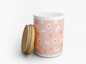 Um frasco para guloseimas cor-de-rosa e branco personalizado com desenhos de ossos para cães, impressões de patas e corações.