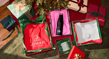 Custom corporate gifts in elegant gift boxes placed under the tree.