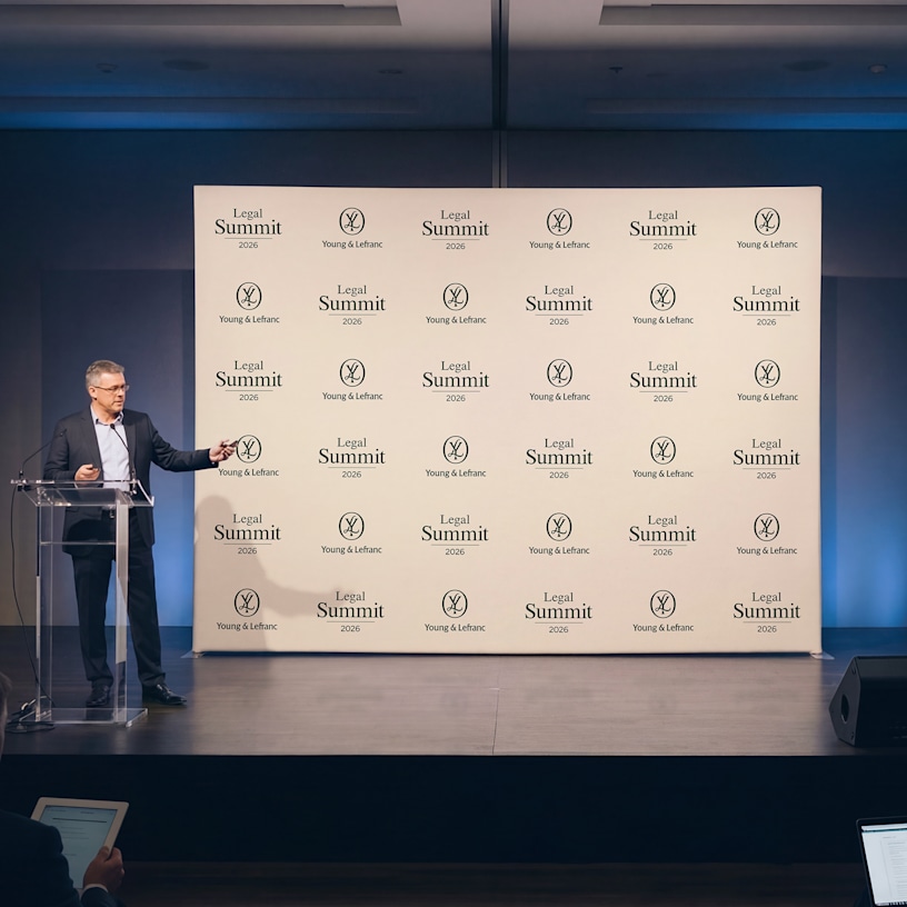 A fabric display wall promoting a legal firm being used at a presentation. 