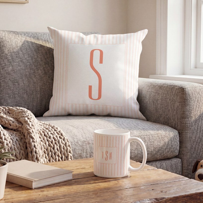 A striped monogram pillow on a couch. 