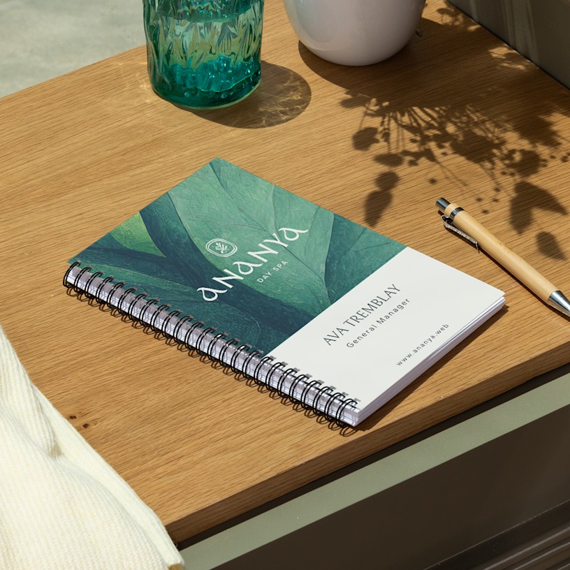 A branded wire-bound booklet promoting a day spa, with a person's name on the cover.