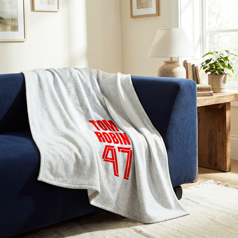 A white sweatshirt blanket printed with an athlete’s name and number. 