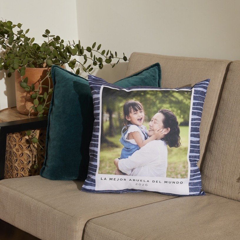 Cojín personalizado en un sofá, impreso con una foto de una abuela y su nieta.   