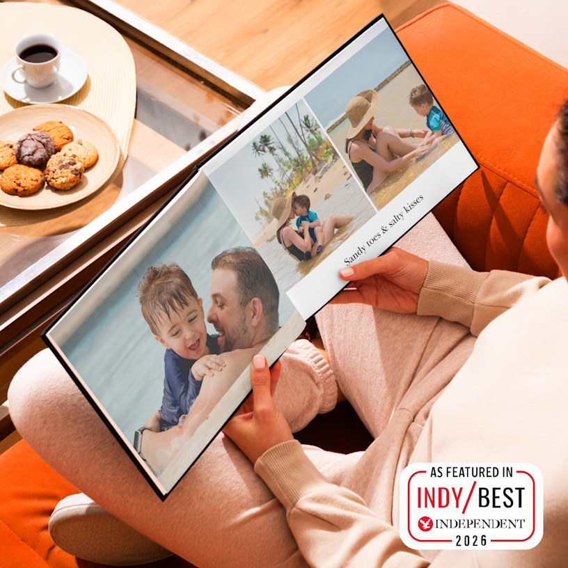 A photo book, open to pictures of a family beach holiday. 