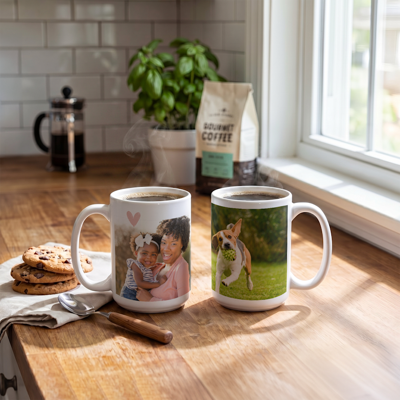 Uma caneca de cerâmica branca a fumegar repousa sobre uma mesa de madeira impressa com o texto personalizado "Dog Mom – Chelsea", com o desenho de uma pata a substituir a letra "o" em "Dog". Um livro, uma caneta e uma pequena planta são visíveis ao fundo.