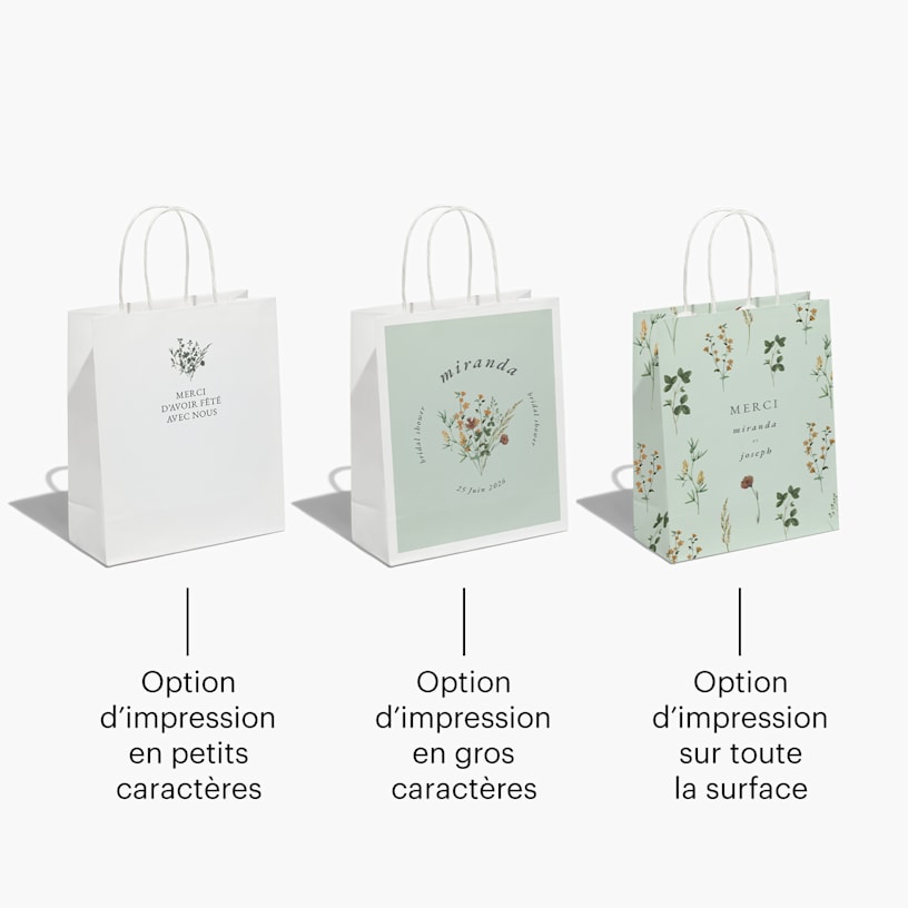 Trois sacs de fête d’un mariage dotées de motifs floraux et remplis de papier de soie couleur saumon.