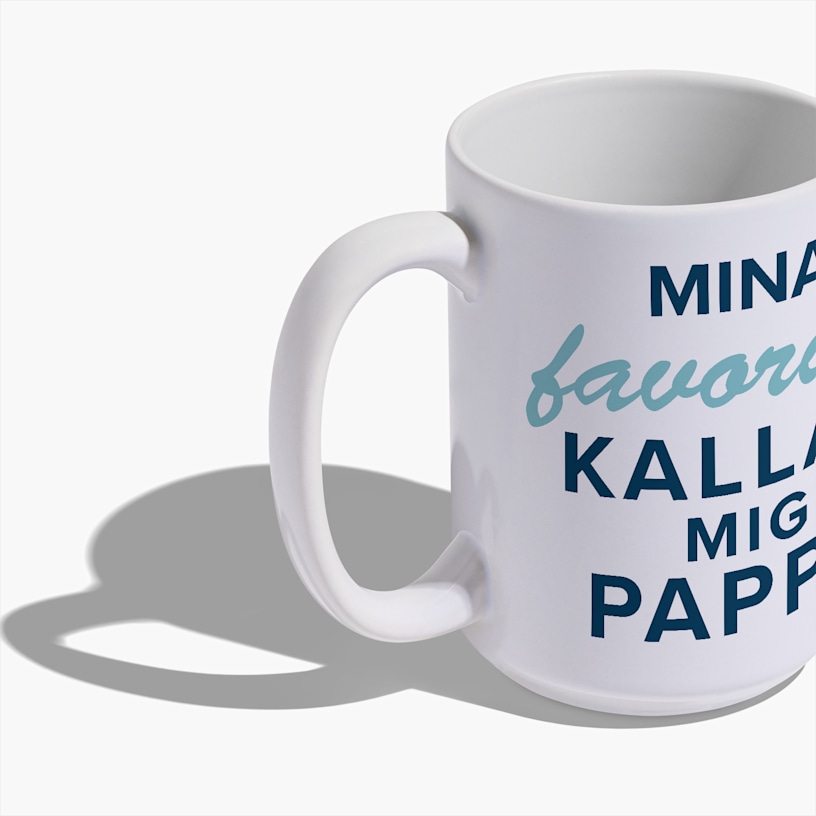 Uma caneca alta em cerâmica branca sobre um fundo branco, impressa com um logótipo botânico minimalista em verde e o nome da marca "Ananya" em texto escuro, com um pequeno slogan por baixo
