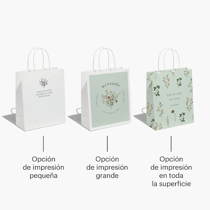 3 bolsas de fiesta para una celebración de boda con estampado floral y rellenas con papel de seda color salmón.