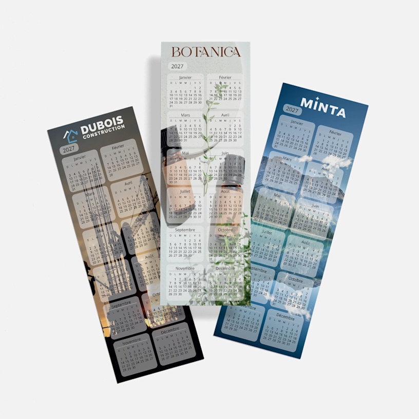 Trois calendriers signets 2027 aux graphismes variés (une entreprise de construction, une fleuristerie et un paysage de montagne), disposés côte à côte.