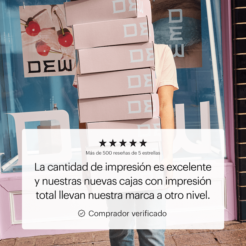Una persona sujetando un conjunto de cajas postales con impresión total frente a una tienda. El comentario destacado de un cliente indica la calidad de la impresión y el look sofisticado de la marca.