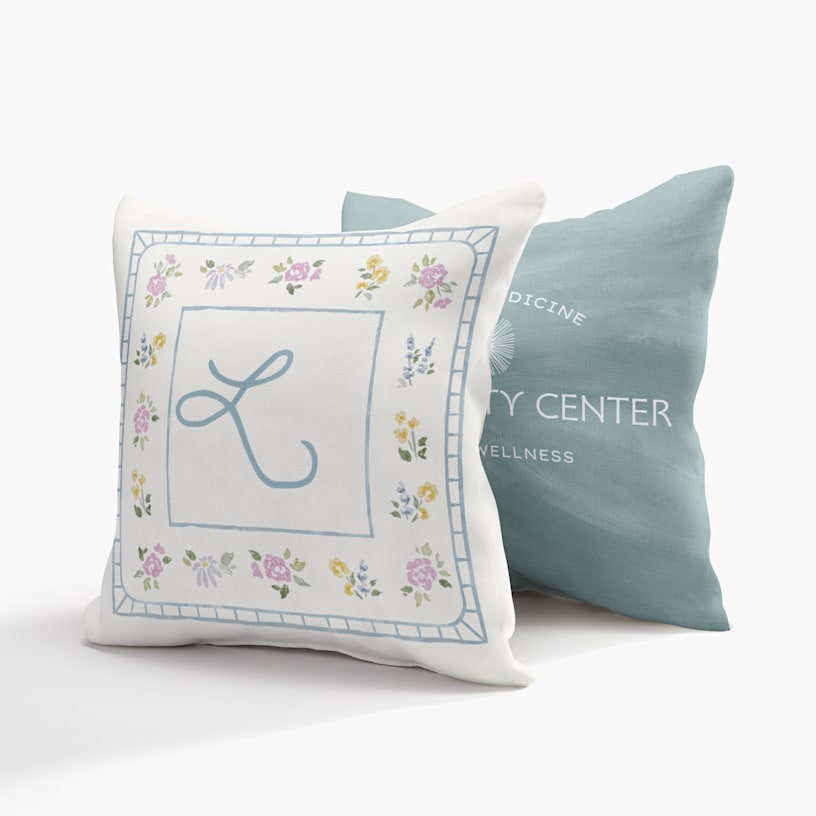 Two custom pillows, one printed with a monogram and the other with the logo and name of a wellness center. 