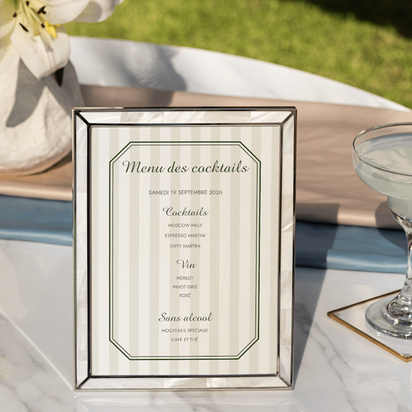 Un menu de cocktails personnalisé à motif rayé, présenté dans un cadre élégant. 