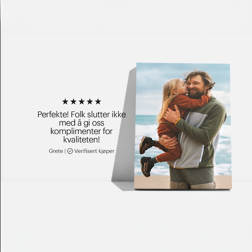 Trykk på lerret med et bilde av en far og datter på stranden, samt en kundeanmeldelse: «Vakkert! Vi får hele tiden komplimenter for kvaliteten!» 