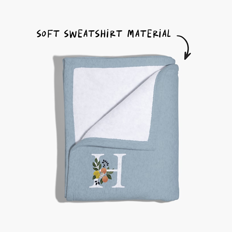 A sweatshirt blanket folded back at the corner, with a note that reads “soft sweatshirt material”. 