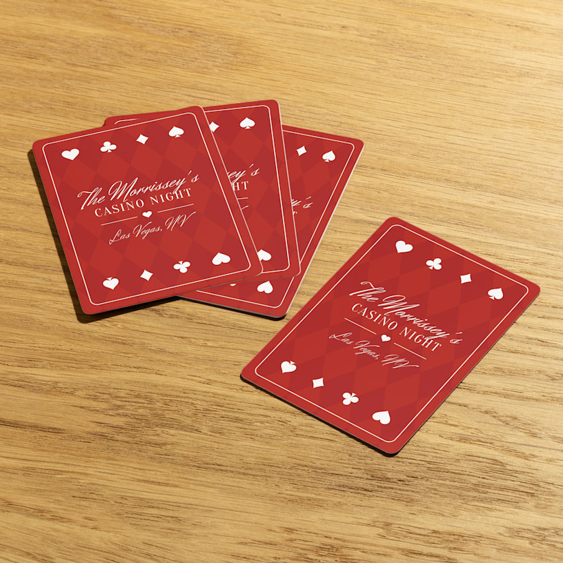 Playing cards customized for a casino night, laid out on a wooden table. 