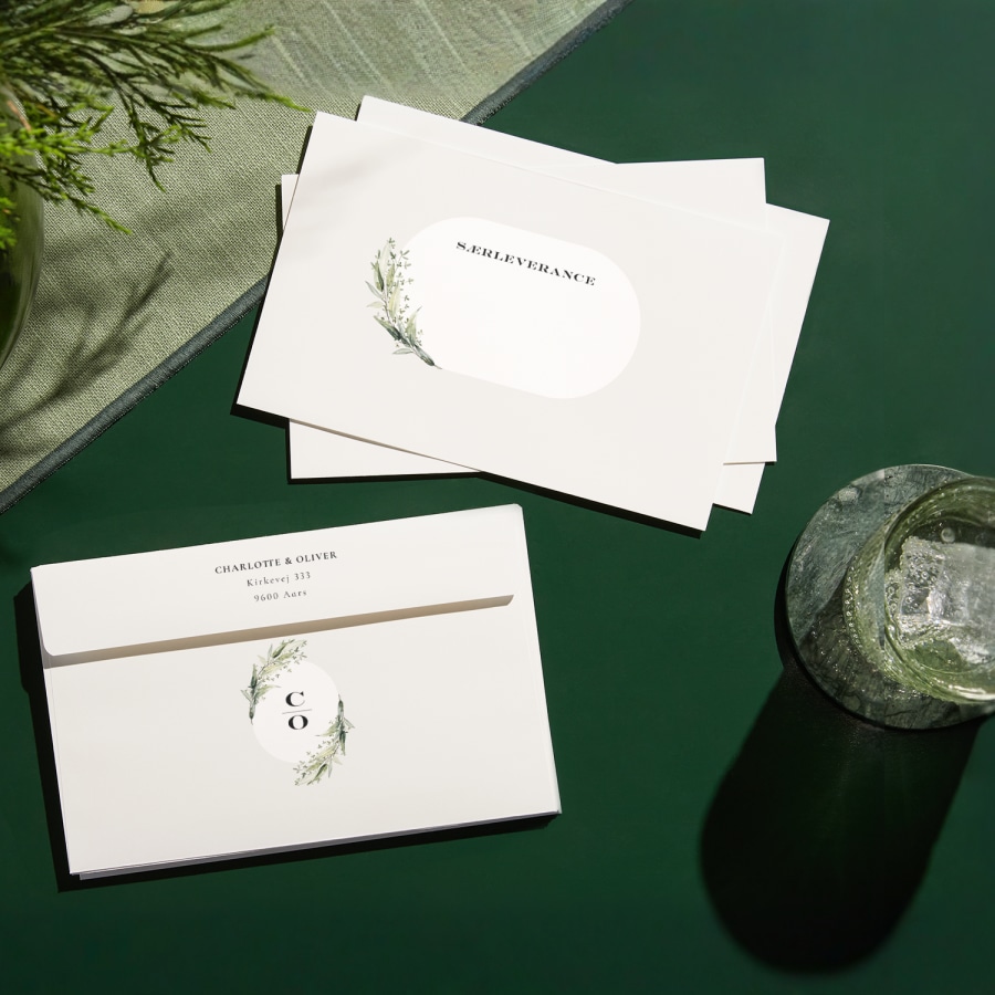 En bunke tilpassede konvolutter trykt med botaniske motiver og en afsenderadresse på konvolutternes flap. 