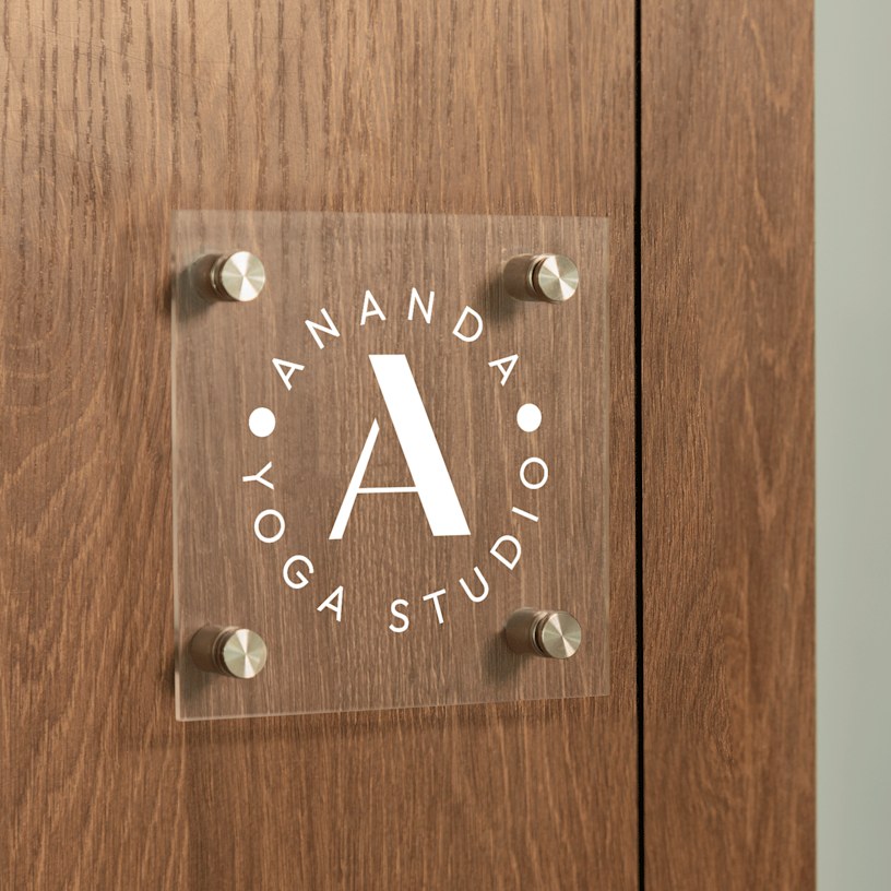 firkantet skilt i akryl med logo på en hvid dør i et kontorområde