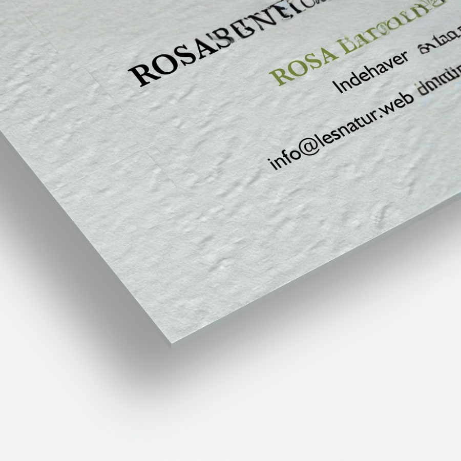 Et nærbillede af teksturerede ubestrøgne visitkort, der viser deres firkantede hjørner og lærredslignende teksturerede papir.