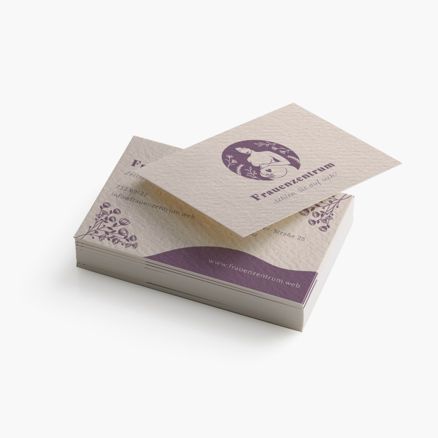 Ein Stapel Visitenkarten mit Strukturpapier, die auf Vorder- und Rückseite ein Frauengesundheitszentrum bewerben.